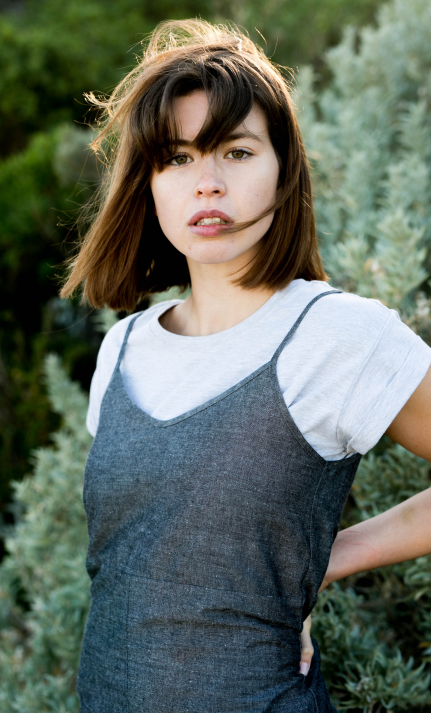 Outdoor portrait of a woman in linen slip dress amongst foliage