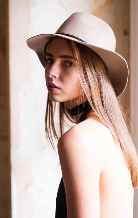 Woman wearing a felt fedora hat in warm afternoon light